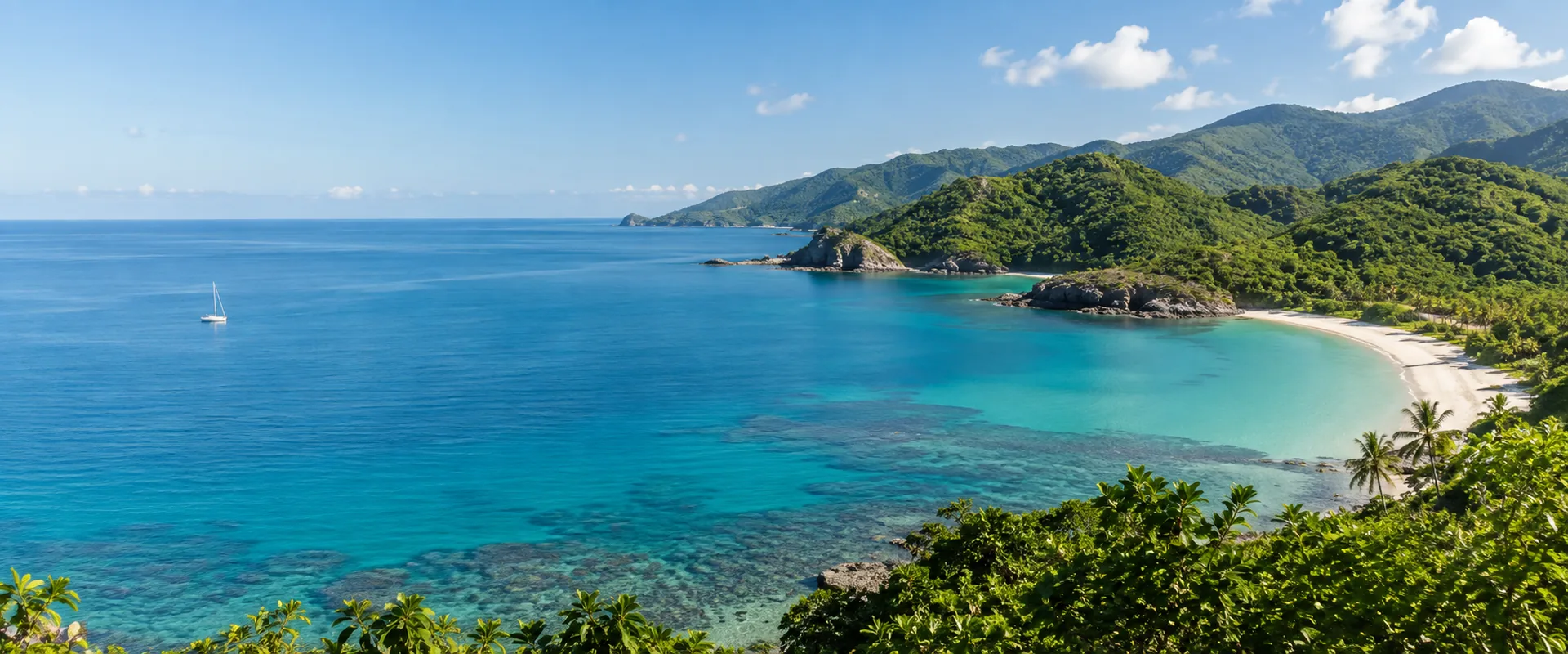 A tropical coastline with turquoise water and lush green hills